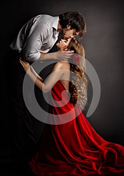 Sensual Couple Kissing in Love. Handsome Man hugging romantic Woman in red Dress. Valentines People Concept