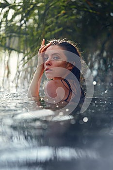 Sensual fasion portrait of woman in the water. Summer emotional, beautiful portrait of a swimming woman resting in the water photo