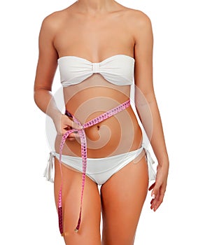Sensual female body with bikini and tape measure