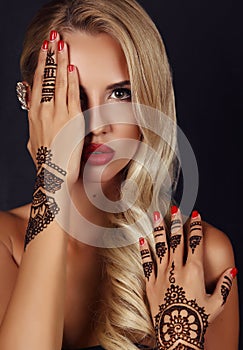 Sensual girl with blond hair with mehendi pattern on hands