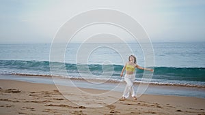 Sensual girl dancing improvisation in modern style at sand beach. Woman spinning