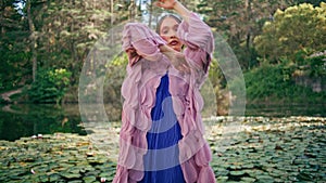 Sensual girl fairy posing at beautiful forest lake covered water lilies close up