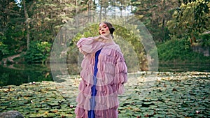 Sensual girl fairy posing at beautiful forest lake covered water lilies close up