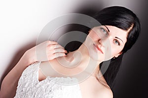 Sensual girl with long curly hair in underwear, sitting and posing on white background. Fashion vogue style portrait