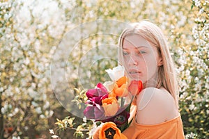 Sensual girl with tulip Flovers. Blonde girll relaxing in the blossom garden. 8 march women`s day.