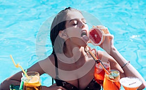 Sensual girl. Young woman reaxing in swimming pool at exotic resort.