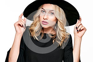 Sensual Halloween Witch Studio Portrait. Attractive young woman dressed in witch halloween costume isolated over white.