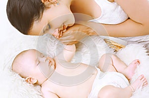 Sensual happy mother amd sleep baby in bed photo