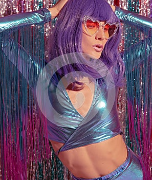 Sensual Lady 80s in stylish holographic party look. Tinsel installation. New year`s clubbing concept. Merry christmas. Holiday.