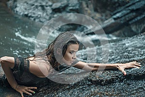 Sensual lady hiking on the wet rocks