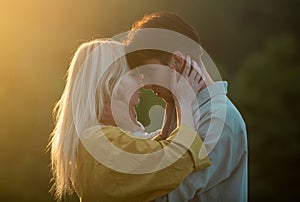 Sensual lovers hugging and kissing at sunset. Young sensual girlfriend glad to passionate kiss from her boyfriend