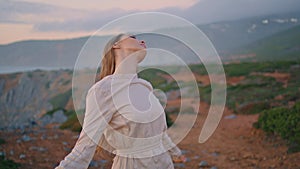 Sensual model touching hair on green hill closeup. Attractive calm woman posing
