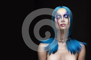 Sensual portrait of beautiful dyed blue hair naked shoulders closed eyes girl wearing necklace. Vanguard fashion make-up.