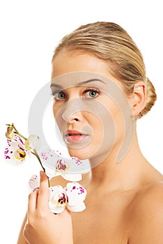 Sensual portrait of nude woman with orchid flower