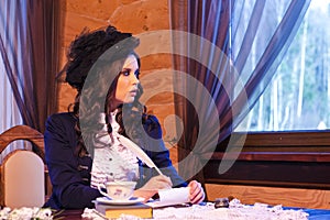 Sensual Portrait of Tranquil Caucasian Brunette Woman With Feather Pen Writing a Letter in Village Environment Indoors