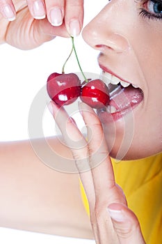 Sensual portrait of a woman eating ripe cherries