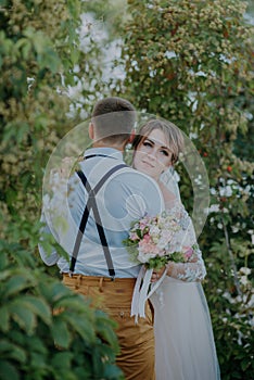 Sensual portrait of a young couple. Wedding photo outdoor. Wedding shot of bride and groom in park. Just married couple