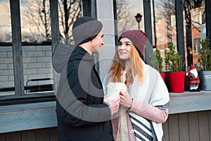 sensual stylish couple in love drinking coffee on the street cafe in cold winter weather, having fun together outdoor