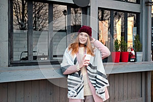 Sensual stylish young woman drinking coffee on the street cafe in cold winter weather