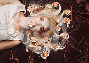 sensual tender woman portrait with unusual magical gaze and peachy roses in hair