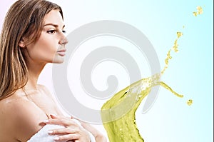 Sensual woman in bathrone near freen splash of tonic lotion.