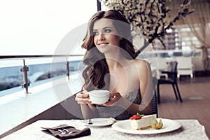 Sensual woman drinking coffee in outdoor summer cafe