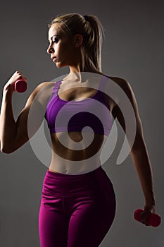 Sensual woman with dumbbell, weightlifting.