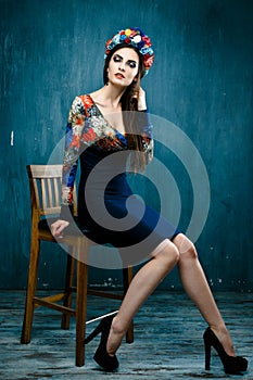 Sensual woman in floral wreath. Portrait of beautiful young woman with red lips dressed in a bright blouse