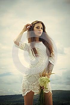 Sensual woman with flowers cloudy sky, beauty