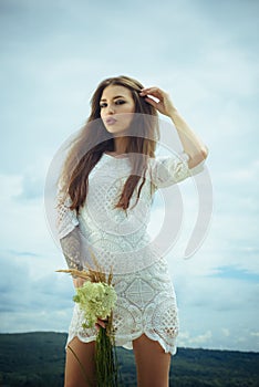 Sensual woman with flowers cloudy sky, beauty