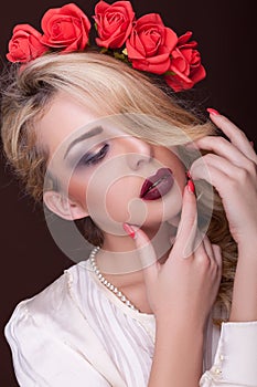 Sensual woman with flowers in head on brown background