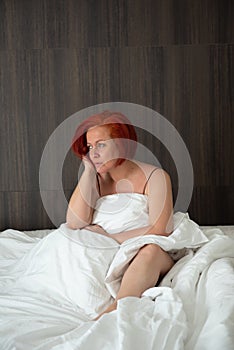 Sensual woman in her bed at dawn, between the sheets of her bedroom at home