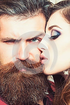 Sensual woman kiss bearded man, love. Woman with makeup skin and hipster with long beard. Couple in love and family