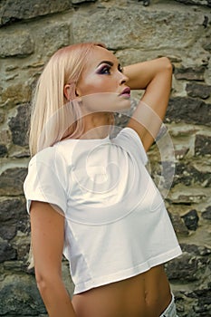 Sensual woman with long blond hair, makeup and beauty. Woman with belly in tshirt, fashion. Fashion model girl pose