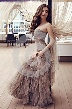 Sensual woman with long dark hair in luxurious sequin dress