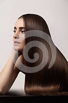 Sensual woman model with straight dark hair. Shiny long health hairstyle