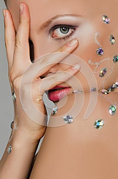 Sensual woman in precious stones covered with palm