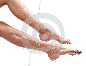 Sensual woman`s legs in clean water splashes.