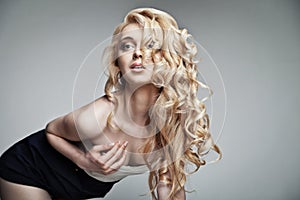 Sensual woman with shiny curly long blond hair