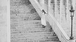 Sensual woman on staircase. Woman bride in white wedding dress, fashion. Girl with glamour look. Fashion model with long