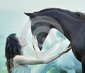 Sensual woman stroking a horse