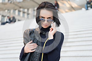 Sensual woman in sunglasses on stairs in paris, france, beauty. Woman with brunette hair in black clothes, fashion. Ambition, chal