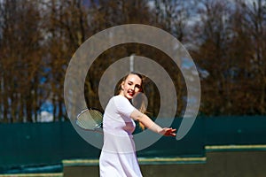 Sensual woman with tennis racket at net on lawn. Activity, energy, power. Sport, training, workout. Wellness, health