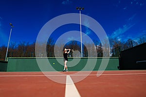 Sensual woman with tennis racket at net on lawn. Activity, energy, power. Sport, training, workout. Wellness, health