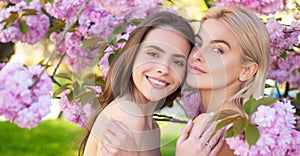Sensual woman spring outdoor portrait banner. Smiling face of sensual girls. Beautiful young girls on blooming pink