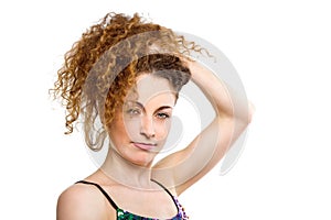 Sensual young woman touching her curly hair