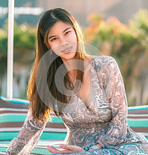 Sensuality Asian woman sitting on a beach sofa on the beach side for Vacation and Relaxation cocnept photo