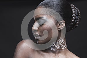 Sensuous African American woman with eyes closed over black background