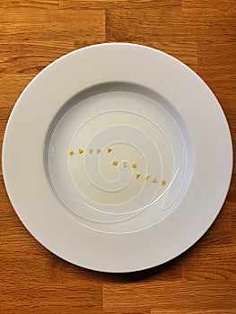 Sentence HAPPY NEW YEAR consists of edible letters. Pasta in form of letters on a plate with wooden background
