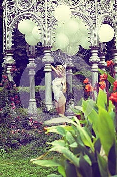 Sentiment. Beautiful Relaxed Blonde holding Air Balloons in the Garden